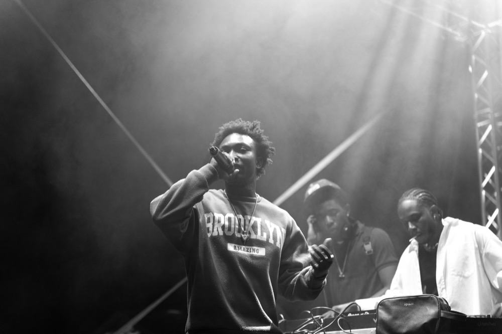 Rapper performing on a festival stage in black and white